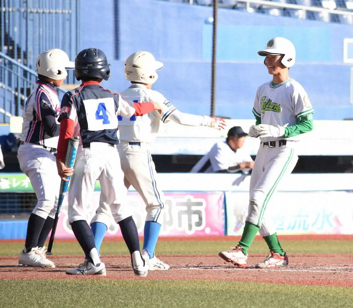 【画像・写真】6回に試合を決定付けるランニング3ランを放ちチームメートに出迎えられる美浜区選抜の松沢（右）