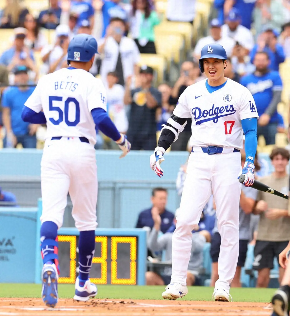 【画像・写真】初回、先頭打者本塁打を放ったベッツ（左）を笑顔で迎えるドジャース・大谷（撮影・光山　貴大）
