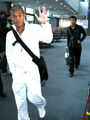 報道陣に手を振り、飛行機に乗り込む亀田興毅（左）と大毅