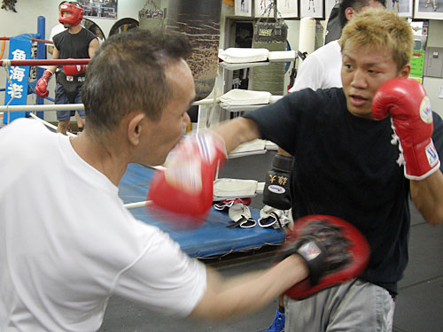 田中トレーナー（左）とミット打ちを行う土屋