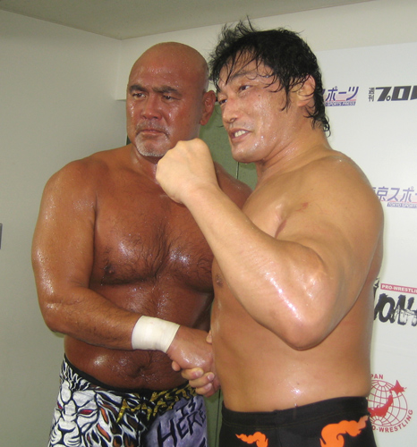 勝利会見でガッチリと握手をかわす武藤（左）と小橋