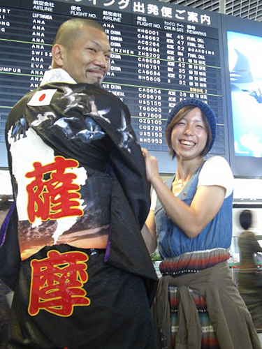 成田空港でガウンを羽織り気合たっぷりの淵上と翔子夫人
