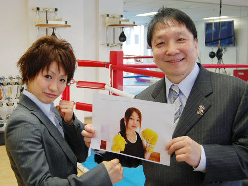挑戦者の秋田屋まさえの写真を手にするＷＢＡ女子ライトミニマム級チャンピオンの宮尾綾香（左）と大橋秀行会長