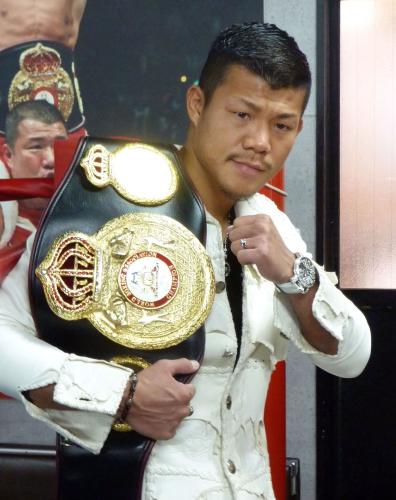 チャンピオンベルトを肩に掛けポーズをとる亀田興毅