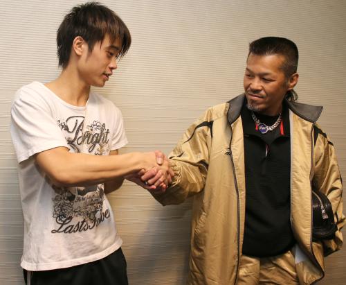 プロテストに合格し、父・丈一郎（右）と握手する辰吉寿以輝