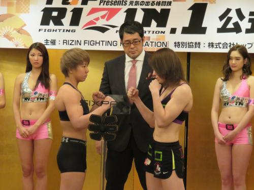 ＲＩＺＩＮ．１で総合格闘技デビューする村田（左）は公式計量後に対戦相手のデニソヴァとにらみ合う。中央は高田統括本部長