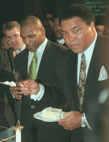 １９９９年１月、マイク・タイソン氏（左）の横で自身の誕生日を祝うバースデーケーキを食べるムハマド・アリ氏（ＡＰ）