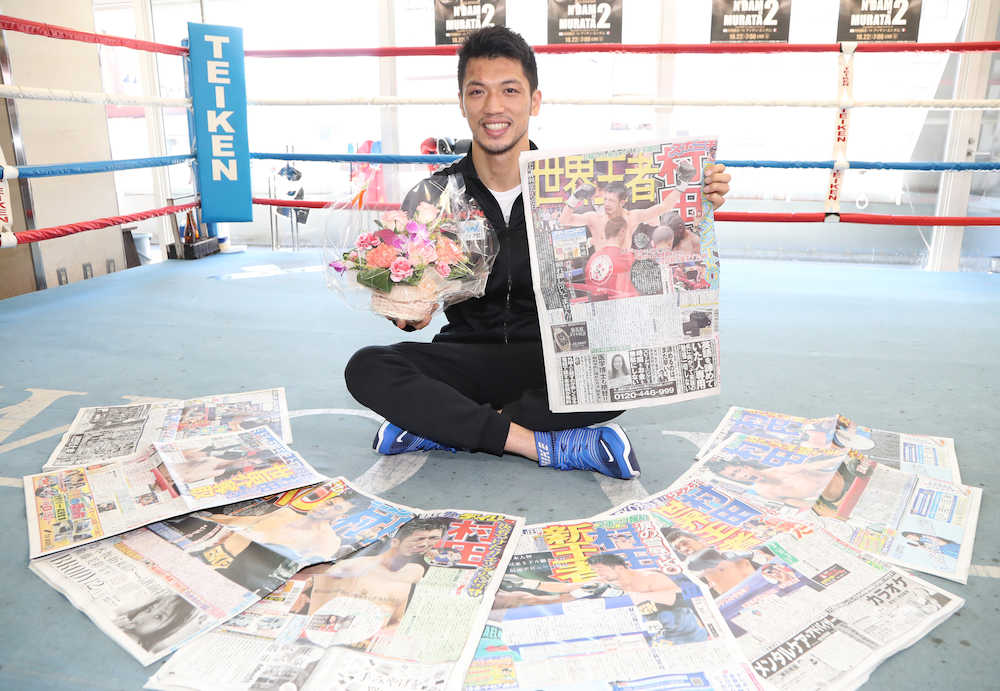 自身が１面を飾ったスポーツ紙各紙を広げ、スポニチを手に笑顔の村田