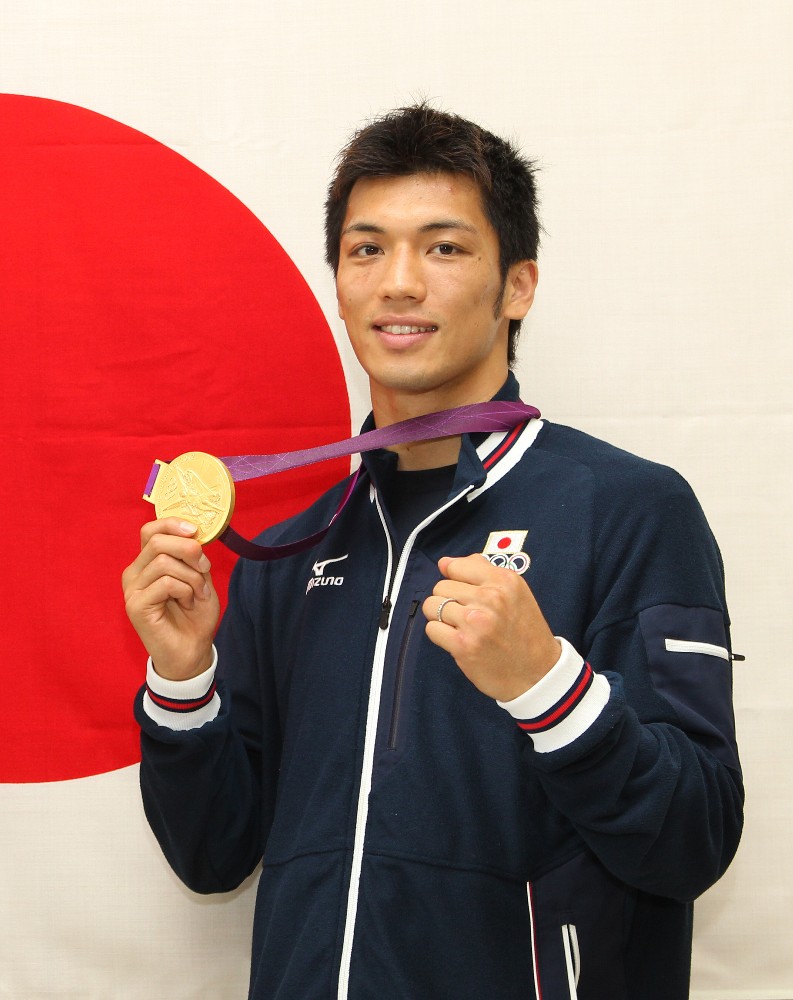 １３年、日の丸を背にメダルを掲げてガッツポーズする、ロンドン五輪男子ボクシングミドル級で金メダルを獲得した村田