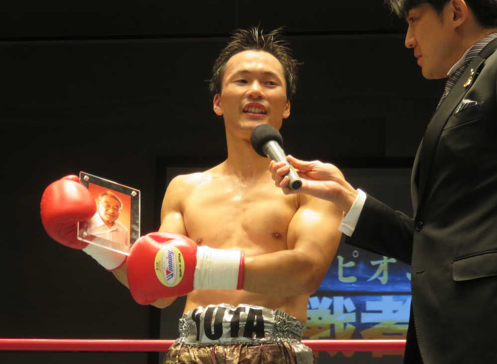 日本スーパーフライ級王者への挑戦権を獲得した松尾は故・高橋美徳氏の遺影を手に笑顔（撮影・中出　健太郎）