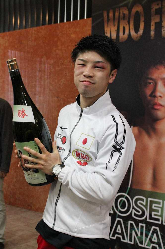 勝利を祝って届けられた特製の清酒を手に笑顔を見せる田中恒成