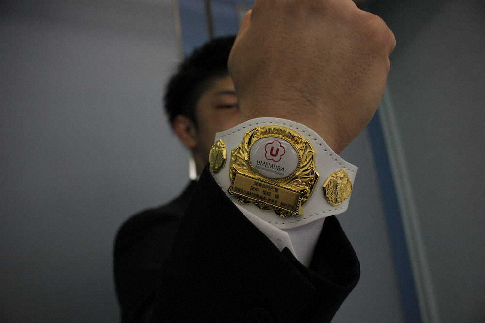 【画像・写真】中京大の梅村理事長から送られた特製のリストバンドをさっそくはめる田中恒成