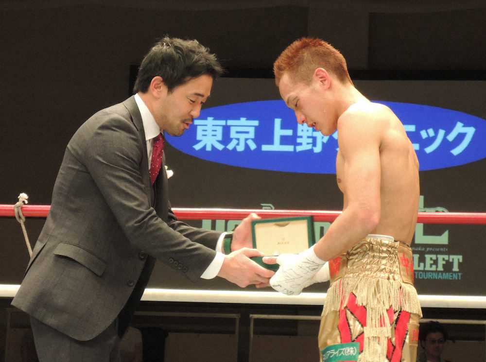 優勝し、山中慎介氏（左）から副賞の高級腕時計を贈られる中嶋一輝