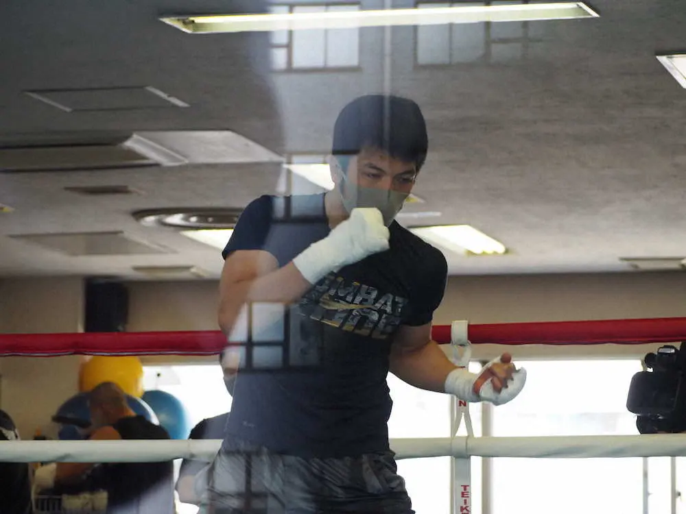 シャドーボクシングを行う村田諒太。公開練習は記者がガラス越しに見学する異例のスタイルで行われた