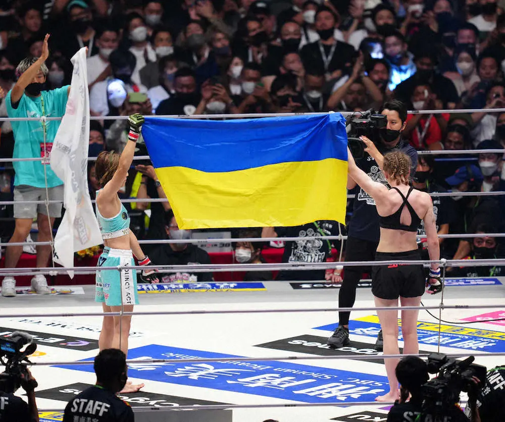 ＜RIZIN38＞勝利した伊沢（左）はアナスタシアとともにウクライナの国旗を掲げる（撮影・島崎忠彦）