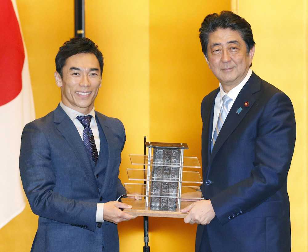 佐藤琢磨選手（左）から記念品を受け取る安倍首相