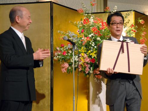 富山県の石井隆一知事（左）から県民栄誉賞の記念品を受け取る、映画「おくりびと」の滝田洋二郎監督