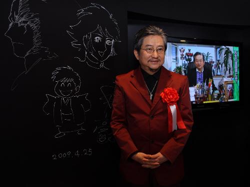 記念館のオープンを記念して、人気キャラクターをボードに描く永井豪」