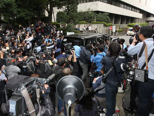 報道陣が殺到する中、東京地裁に入る押尾学被告を乗せた車両