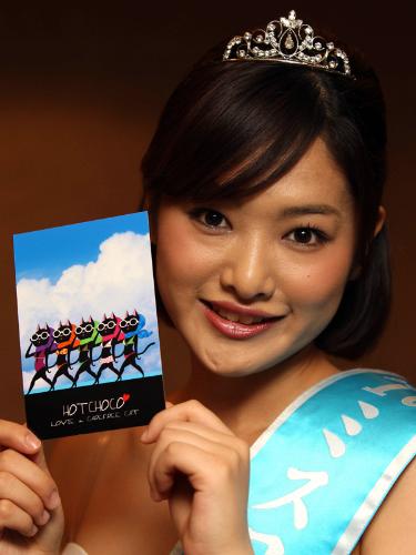 自らがデザインしたポストカードを手に笑顔を見せるミス日本「空の日」の林愛さん