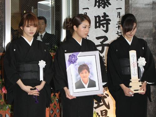 母・時子さんの出棺の時を迎え、目に涙を浮かべながらぼう然と立ち尽くす（左から）後藤真希、次女、長女