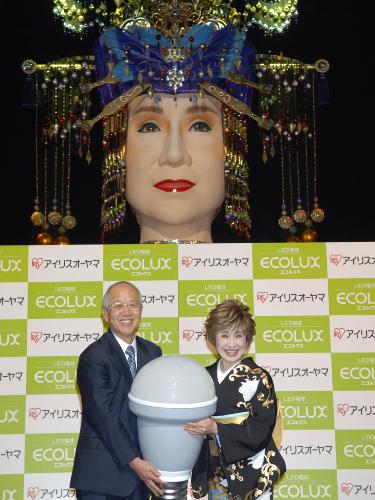 巨大人形「メガ幸子」の前で、ＬＥＤ電球の新商品を紹介する歌手の小林幸子（右）とアイリスオーヤマの大山健太郎社長