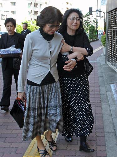 涙を堪え吉岡治氏遺体が安置されている事務所マンションに入る久江夫人（左）と石川さゆり