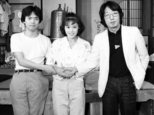 １９８３年６月、ＮＨＫ銀河テレビ小説・つかこうへいの「かけおち」のセットで、出演者の（左から）長谷川康雄さん、大竹しのぶさんと握手するつかこうへいさん
