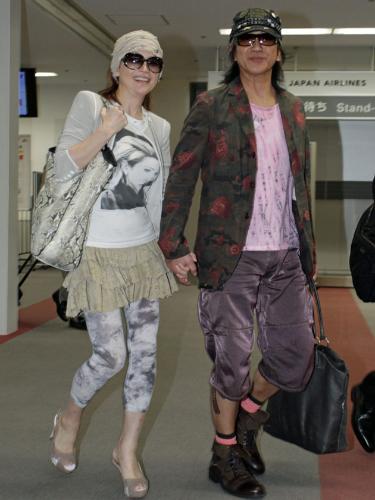 旭川から空路、羽田空港に戻ってきた玉置浩二（右）と青田典子は手を握り合って飛行機から降りる