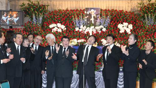 平尾昌晃（中央・マイク）ミッキー・カーチス（平尾の左隣３人目ら音楽仲間が「ダイアナ」を歌って山下さんを送り出す