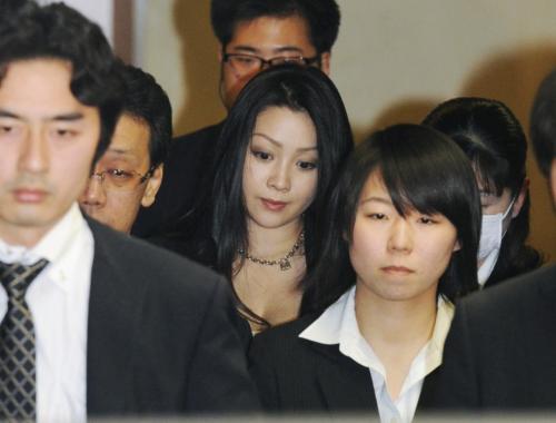 逮捕され捜査員に囲まれて成田空港を出るタレントの小向美奈子容疑者（中央）