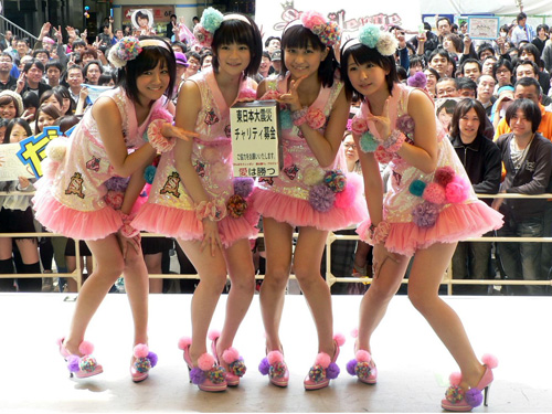 東日本大震災の募金箱を手に、ファンをバックにポーズをとるスマイレージ（左から）小川紗季、前田憂佳、和田彩花、福田花音