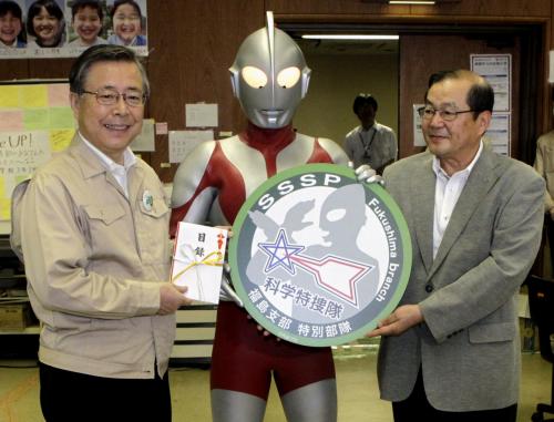 福島県の佐藤雄平知事（左）に寄付金を手渡したウルトラマンと円谷プロダクションの大岡新一社長