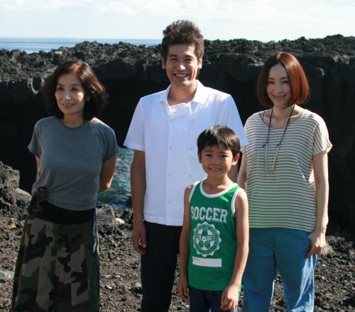 映画「ロック」ロケ地の三宅島を訪れた（左から）倍賞美津子、佐藤隆太、土師野隆之介、麻生久美子。背景は島の観光名所「メガネ岩」
