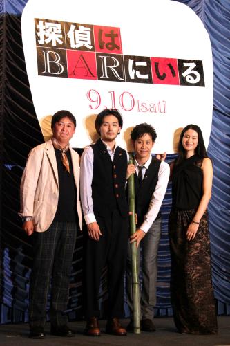 映画「探偵はＢＡＲにいる」完成披露試写会で、巨大うちわでヒットを祈願する（左から）橋本一監督、松田龍平、大泉洋、小雪