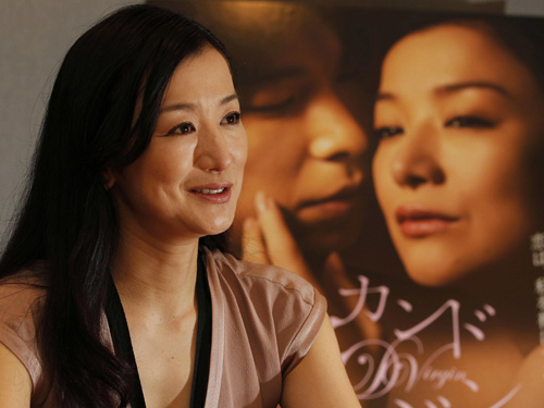 映画「セカンドバージン」のポスターを背にインタビューに答える鈴木京香