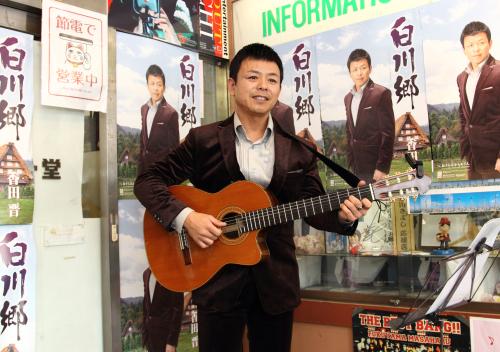 店頭で新曲『白川郷』をギターを弾きながら生歌で披露する香田晋