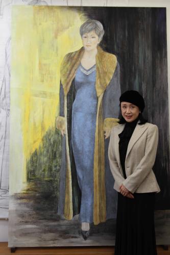 日展に展示されている自身がモデルになった日本画「今日そして明日」を前に微笑む小林幸子