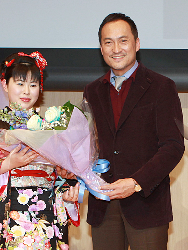 独協大学で行われた講演会で学生から花束を贈られる渡辺謙