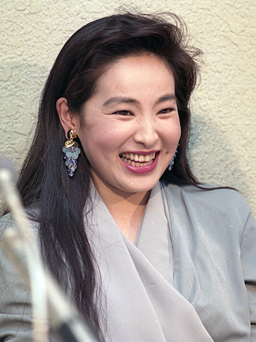 ９０年４月、会見で笑顔をみせる山口美江