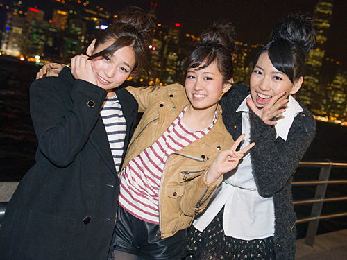 香港の夜景をバックに笑顔を見せる（左から）仲川遙香、前田敦子、増田有華