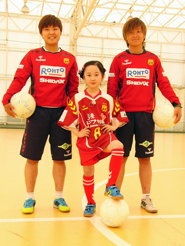 ＩＮＡＣ神戸の田中明日菜（右）と池笑然（左）にサッカーを教えてもらい笑顔の本田望結