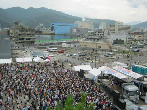 会場の周囲は津波被害で更地が目立つ。後方が釜石漁港