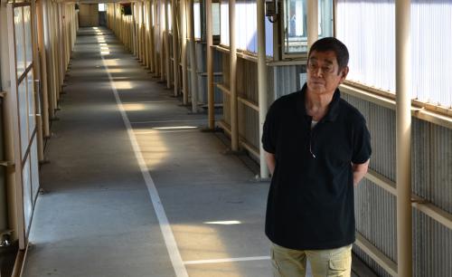 撮影にも使われた富山刑務所の長い廊下に立つ高倉健