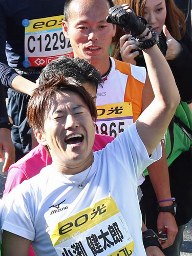 ＜大阪マラソン＞ゴールし、万感の表情でガッツポーズするコブクロの小渕健太郎