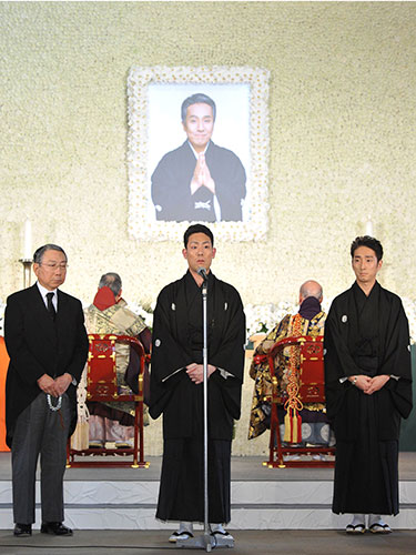 父の遺影の前で参列者へ喪主挨拶をする中村勘九郎。右は中村七之助、左は松竹・大谷信義会長