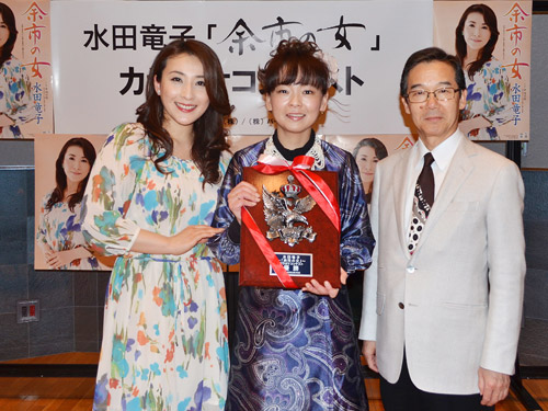 左から水田竜子、優勝者・山本のり子さん、審査員長の作曲家・水森英夫さん