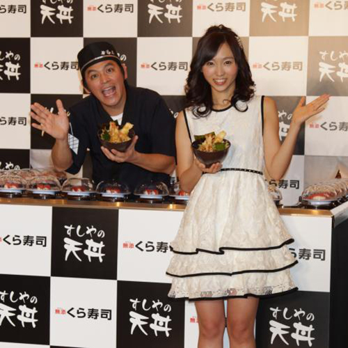 くら寿司が３月１日から販売する新商品「すしやの天丼」を手に笑顔でポーズをとる岡田圭右と吉木りさ