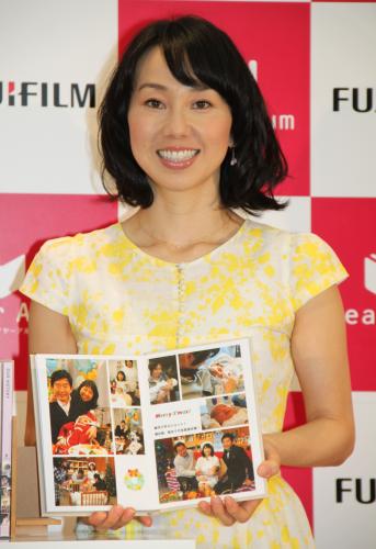 富士フィルムの新サービス「イヤーアルバム」記者発表会で出来上がったフォトブックを手に笑顔を見せる東尾理子