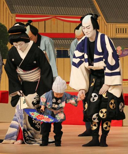 十八代目中村勘三郎さんにささげる舞踊「お祭り」で、息子の七緒八くんの手を取りあいさつする中村勘九郎（右）。左は中村七之助